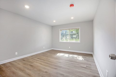 A room with a window and wooden flooring.at Palisades Apartments, Missouri